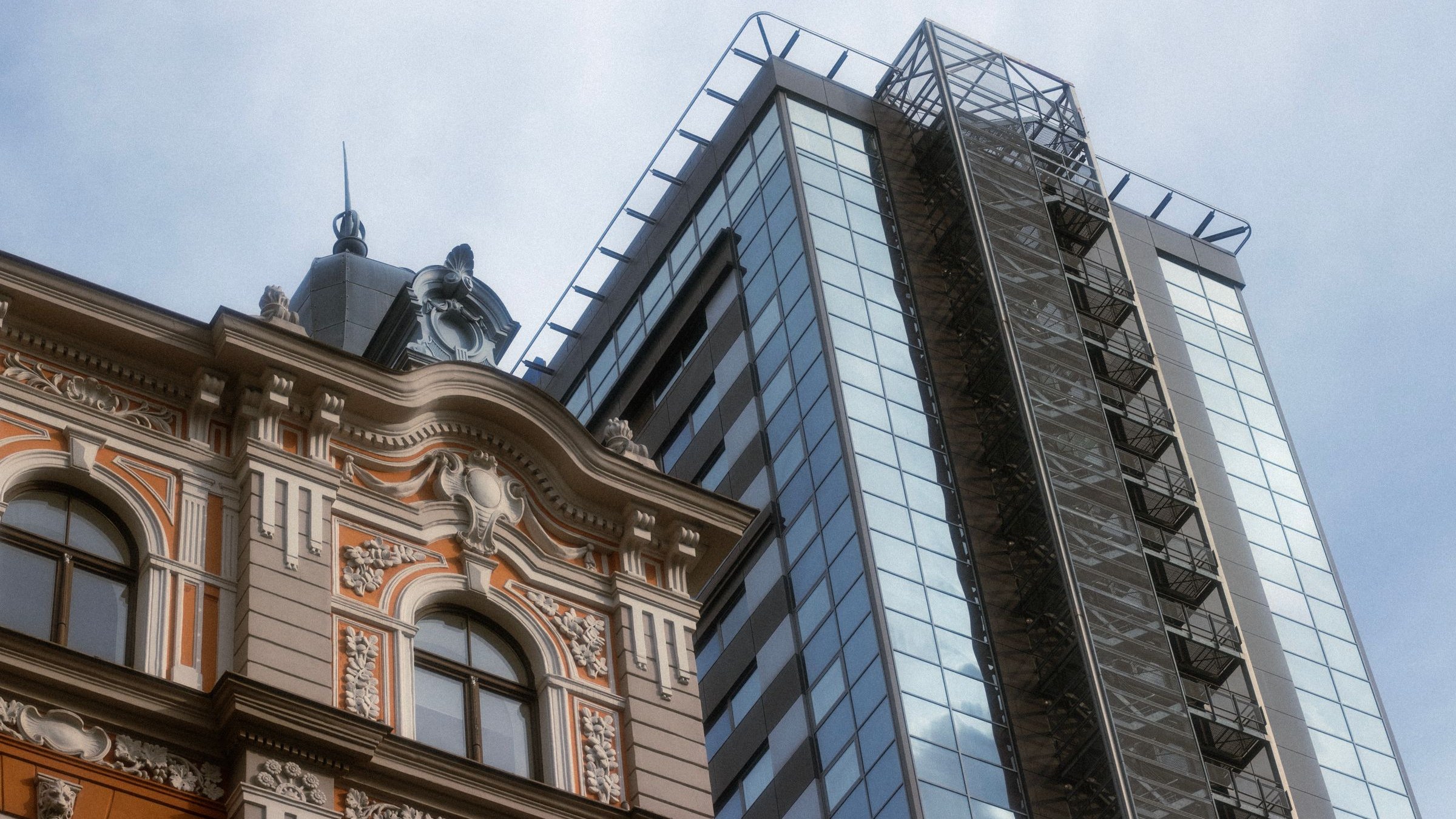 Façade ancienne ouvragée devant une tour de verre neuve : la rentabilité du Pinel se joue dans l’écart de prix entre le neuf et l’ancien